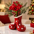 LUMIDED® double santa boots Christmas ceramic vase full product view on marble table with Christmas tree and sofa background, filled with red amaryllis, white baby's breath, red berries and pine sprigs in full festive arrangement
