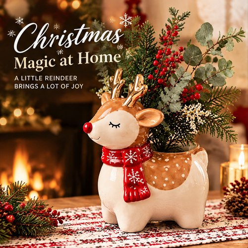LUMIDED® baby reindeer ceramic Christmas vase with white round body, caramel spotted back, gold antlers, red nose, closed eyes and red snowflake scarf, filled with red berries, cedar and eucalyptus arrangement on festive table runner with fireplace background