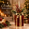 LUMIDED® set of three red and gold metal Christmas gift box planters with gold bow accents, filled with holiday botanicals including red berries, white blooms and pine branches, displayed on marble table